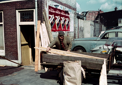849841 Afbeelding van een man die hout laadt in een bakfiets bij een onbekend huis te Utrecht met huisnummer 93.